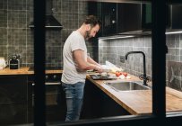 Reifer Mann steht in Küche und schneidet Zwiebeln — Stockfoto