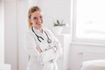 Portrait of smiling female doctor with crossed arms — Stock Photo