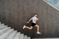 Male athlete running down stairs — Stock Photo