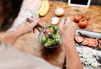 Reifer Mann steht in Küche und bereitet Salat zu — Stockfoto
