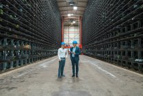 Deux hommes d'affaires se réunissant dans un entrepôt haut de gamme d'une usine — Photo de stock