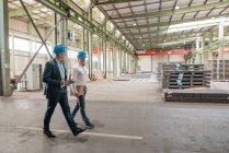 Dois empresários tendo uma reunião e andando em uma fábrica — Fotografia de Stock