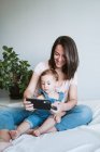Mother and baby girl taking a selfie with smartphone at home — Stock Photo