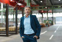 Ritratto di un uomo d'affari maturo e sicuro di sé in una fabbrica — Foto stock