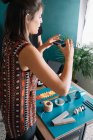 Jeune femme créative prenant photo smartphone de la décoration sur la table — Photo de stock