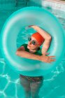 Retrato de mujer con neumático flotante en piscina - foto de stock