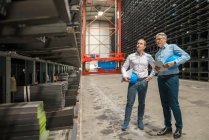 Deux hommes d'affaires se réunissant dans un entrepôt haut de gamme d'une usine — Photo de stock