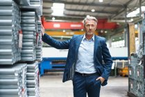 Portrait of a confident mature businessman in a factory storehouse — Stock Photo