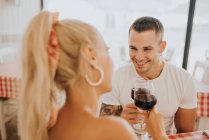 Felice giovane coppia brindare bicchieri da vino nel ristorante — Foto stock