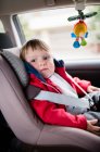 Bonito menino olhando para longe enquanto sentado no assento do carro — Fotografia de Stock