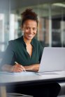 Portrait of smiling businesswoman working at desk — Stock Photo
