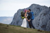 Baciare la coppia di sposi con gli zaini da arrampicata a Urkiola, Spagna — Foto stock