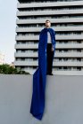 Бізнесмен в супергеройському мисі, що стоїть на стіні в місті — стокове фото