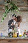 Coppia brindisi champagne flauto mentre abbraccia a tavola — Foto stock