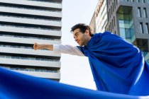 Бізнесмен в супергеройському мисі в місті стискає кулак — стокове фото