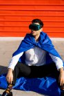 Бізнесмен у супергеройському накидку та окулярах VR, що сидять на борту — стокове фото