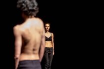Männliche und weibliche Tänzer führen zeitgenössisches Ballett auf schwarzer Bühne auf — Stockfoto
