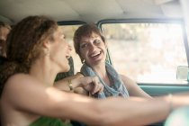 Amigos sorridentes sentados no carro durante a viagem de carro — Fotografia de Stock