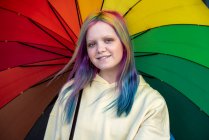 Portrait of young woman with dyed hair under umbrella - foto de stock