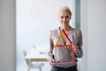 Confident female entrepreneur holding model while standing in office — Stock Photo