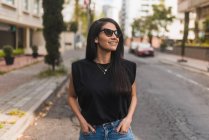 Жінка дивиться з руками в кишені на вулиці в місті — стокове фото