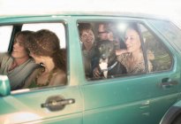 Sorrindo amigos masculinos e femininos sentados no carro durante a viagem de carro — Fotografia de Stock