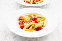 Piatto di pasta vegetariana con mozzarella, pomodorini e basilico — Foto stock