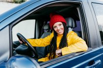 Sorridente donna guida auto durante il viaggio su strada — Foto stock