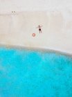 Maschio turista rilassante mentre sdraiato sulla spiaggia durante le vacanze — Foto stock