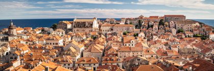 Croácia, Dubrovnik, Edifícios da cidade velha com telhados laranja com mar no fundo — Fotografia de Stock