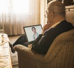 Paziente anziano di sesso maschile che riceve consigli online dal medico femminile tramite tablet digitale — Foto stock