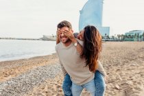 Young man giving his girlfriend a piggyback ride on the beach - a Royalty  Free Stock Photo from Photocase