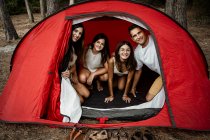 Lächelnde Familie verbringt Freizeit im Zelt im Urlaub — Stockfoto