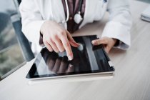Experiencia médica femenina utilizando mesa digital en el escritorio en el hospital - foto de stock