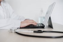 Medico senior donna che lavora su tablet digitale alla scrivania in ospedale — Foto stock