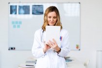 Жіночий медичний працівник використовує цифровий планшет вдома — стокове фото