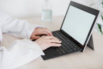 Profesional médico femenino usando tableta digital en el escritorio en la clínica médica - foto de stock
