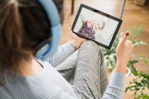 Mother showing thumbs up to daughter on video call through digital tablet — Stock Photo