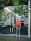 Confident female entrepreneur with arms crossed against office building — Stock Photo