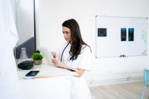 Doctora usando tableta digital en clínica - foto de stock