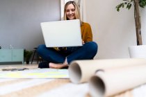 Sorridente donna d'affari creativa utilizzando il computer portatile in ufficio — Foto stock