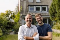 Cheerful father and son standing in backyard — Stock Photo