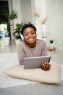 Mujer emprendedora sonriente usando tableta digital en casa - foto de stock
