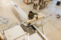 Falegname maschio che lavora con materiale in legno a tavola sega in officina — Foto stock