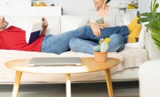 Paar diskutiert miteinander, während es sich zu Hause auf dem Sofa entspannt — Stockfoto