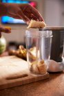 Femme préparant smoothie banane dans la cuisine — Photo de stock