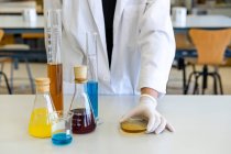 Giovane scienziata con piastra oggetto e attrezzatura di laboratorio alla scrivania — Foto stock