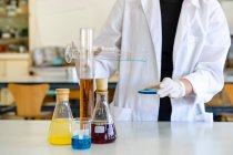 Giovane scienziata esaminando chimica su piastra oggetto in laboratorio — Foto stock