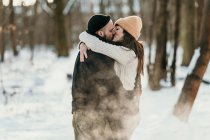 Mid adult boyfriend and girlfriend kissing in forest — Stock Photo