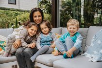 Smiling mother with children on sofa at backyard — Stock Photo